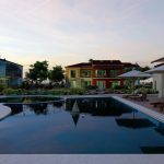 Top-down site map view of eight detached villas with a communal swimming pool and landscaped gardens in Turkey