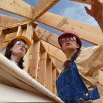 Residential house under construction in Turkey with scaffolding, workers, and building materials on site