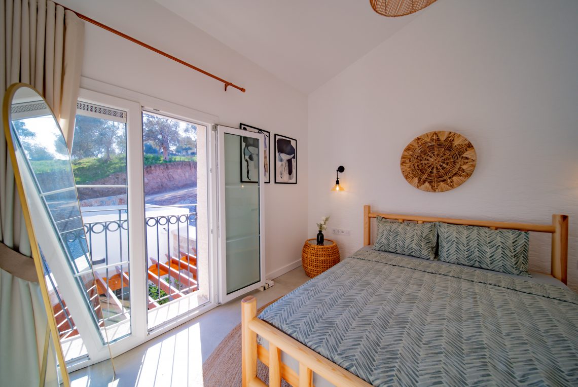 Modern bedroom with large windows, double bed, and soft lighting