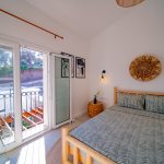 Modern bedroom with large windows, double bed, and soft lighting