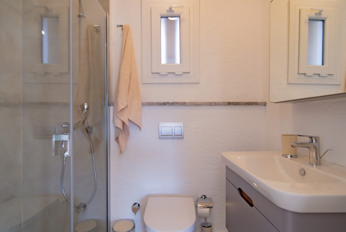 Modern toilet with tiled walls and sleek sanitary ware