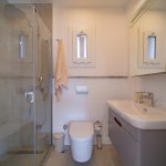 Modern toilet with tiled walls and sleek sanitary ware