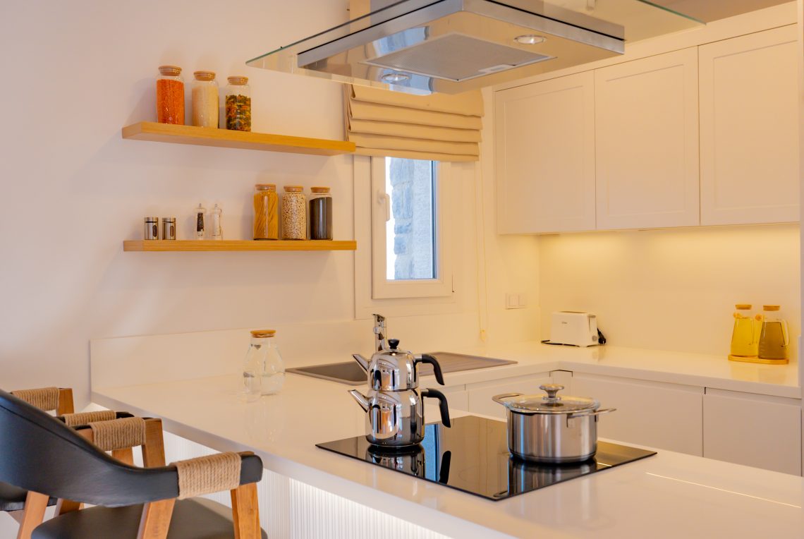 Modern kitchen with built-in appliances, white cabinets, and island counter