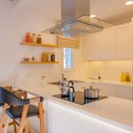Modern kitchen with built-in appliances, white cabinets, and island counter