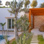 Stone garden path leading to a swimming pool surrounded by lush greenery